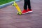 Close up legs in red sneakers riding on yellow skateboard in motion. Active urban lifestyle of youth, training, hobby, activity