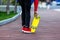 Close up legs in red sneakers riding on yellow skateboard in motion. Active urban lifestyle of youth, training, hobby, activity