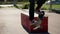 Close up of legs of skateboarder grinding over ledge in summer day outdoors. Teenager on board is sliding on barrier