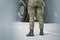 Close up of legs of soldier standing in front of metal tank