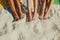 Close up of legs of three women at the beach