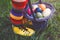 Close-up of legs of toddler girl with colorful stockings and shoes and basket with colored eggs. Child having fun with