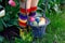 Close-up of legs of toddler girl with colorful stockings and shoes and basket with colored eggs. Child having fun with