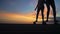 Close-up of the legs of two girls girlfriend in shorts and sneakers ride skateboards on the slope against the beautiful