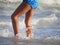 Close up of the legs of an unrecognizable girl wading in the beach