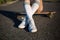 Close up legs in white stocking of girl sit on longboard