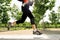 Close up legs of young man running in city park with trees on summer training session practicing sport healthy lifestyle concept