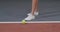 Close-up, legs of a young woman tennis player in white sneakers, during a game