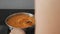 Close - up of lentils and carrots stewing in a steel pan on the stove. Woman spoon stirs the cooking dish.