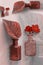 Close up levitating glass bottles with leaf,petunia flowers,red pink color shades, floral fragrance concept,copy space