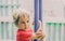 Close up lifestyle side photo. Portrait little boy happy look far away right distance hanging on pipe sport metal