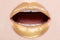 Close-up lips make-up with gold. Open mouth