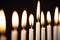 Close Up Of Lit Candles On Metal Hanukkah Menorah Against Black Studio Background