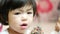 Close up of little Asian baby girl enjoyed eating chocolate icecream with rainbow toppings - baby`s development on their feeling