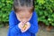 Close-up little Asian child girl holding some colored coated chocolate candy in her hands