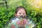 Close up little Asian kid girl holding chinese style fan hide her face in the garden under sunlight