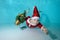 Close-up of a little boy in a Santa Claus costume underwater in the pool. He holds a Christmas tree in his hands and