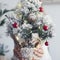Close up of little christmas tree showed from woman hands hidden behind. Holiday december celebration season life concept. White