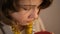 Close-up of little female child drinking tea at home, Christmas atmosphere