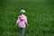 Close-up of a little girl lost, walking across a field