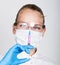 Close-up little girl in a medical dress and gloves holding a syringe