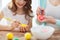 Close up of little girl and mother coloring eggs