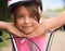 Close-up of a little girl`s face on bike looking at camera and smiling