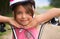 Close-up of a little girl`s face on bike looking at camera and smiling