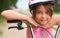 Close-up of a little girl`s face on bike looking at camera and smiling