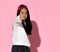 Close up of little Korean girl in red cap and white sweater showing cool sign to camera.