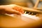 Close-up of a little student\'s hand playing the piano. Happy young Asian girl learning and practicing the piano.