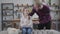 Close-up of little teenage girl with braided pigtails sitting on sofa and talking with bearded father. Happy daughter