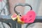 Close-up on locks of hearts in different colors and shapes hanging on the fence as a sign of eternal love, which is hung during