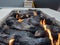 Close up of logs burning in a large, white, stone fire pit