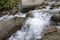 Close-up and long exposure of water flowing through rocks. Foggy image