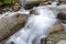 Close-up and long exposure of water flowing through rocks. Foggy image