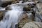 Close-up and long exposure of water flowing through rocks. Foggy image