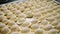 Close-up of lot of dumplings. Clip. Batch of fresh cooked dumplings. Cooking and modeling of dumplings for industrial