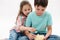 Close-up lovely children kids - preteen boy and cute baby girl eating popcorn, isolated over white studio background