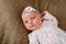 Close-up lovely newborn baby girl on a blanket. A portrait of a beautiful  newborn baby girl wearing a headband. Closeup photo