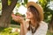 Close up of lovely young girl in summer hat spending time at the park,