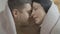 Close-up of loving adult Caucasian couple rubbing noses and smiling covered with blanket. Happy husband and wife or