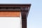 Close up low angle top view photo of brown roof corner with wooden elements on top of small comfortable house with white walls