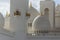 Close-up low key light of marble domes of Sheikh Zayed Grand Mosque with blue sky in the morning at Abu Dhabi, UAE