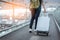 Close up lower body of woman traveler with luggage suitcase going to around the world by plane. Female tourist escalator