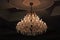 Close up luxury crystal chandelier hanging under ceiling in the room.