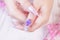 Close up luxury woman hand manicure with long acrylic extension stiletto style painting sweet ombre pink glitter decorated with