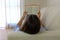 Close up of lying woman reading book relaxing at home. Back view of girl lying on couch enjoying reading a book