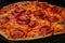 Close up, macro: burnt homemade pepperoni pizza on tray in electric oven