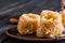 Close up, macro. Eastern sweets on an old clay saucer. Turkish traditional Baklava bird`s nest. Dark wooden background